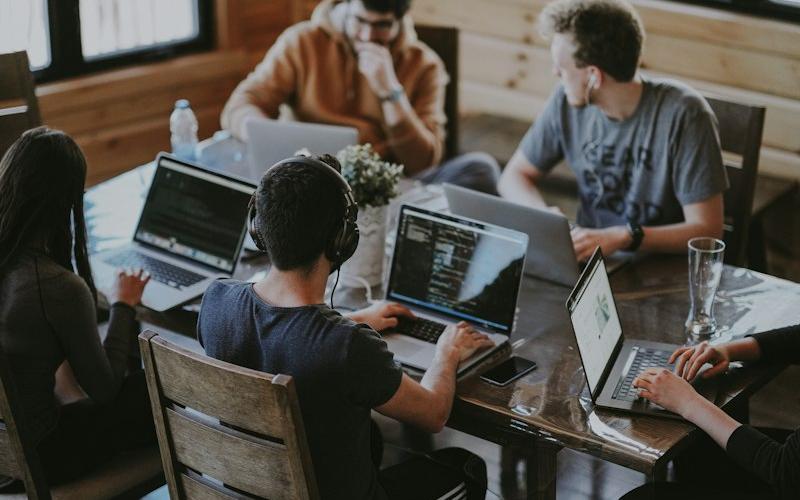 IT support team helping users at laptops