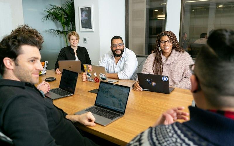 Business team meeting around a table with laptops